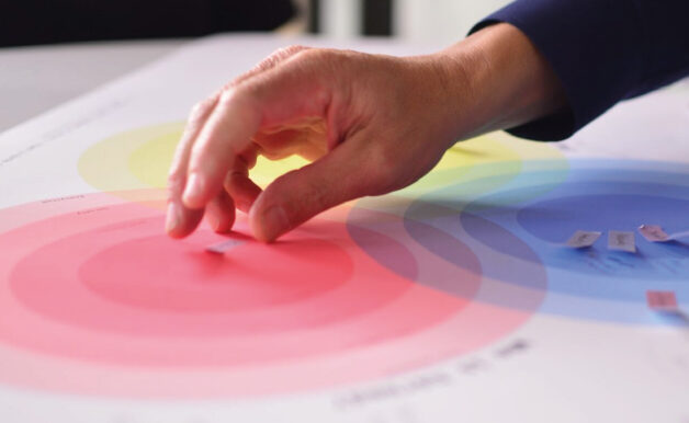 Hand places a sticker on a colour graphic
